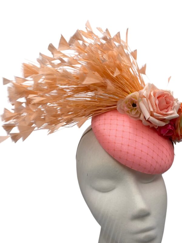 Coral headpiece with a stunning spray of coral feathers and finished with complementary coloured flowers.