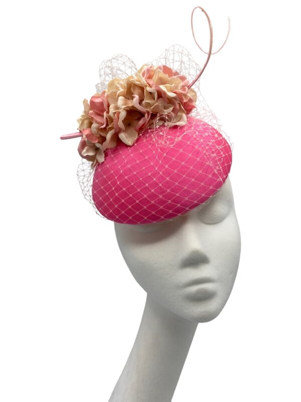 Stunning coral pink headpiece with complementary flowers and veiling to match.
