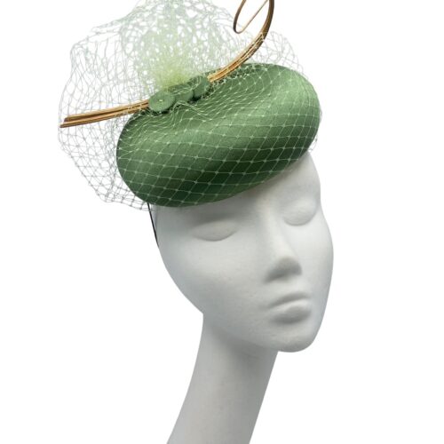 Olive green pillbox headpiece with stunning veiling overlay and gold quill detail to finish.