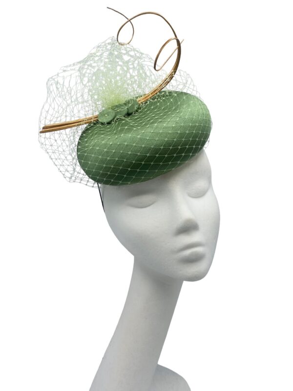 Olive green pillbox headpiece with stunning veiling overlay and gold quill detail to finish.