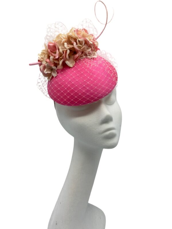Stunning coral pink headpiece with complementary flowers and veiling to match.