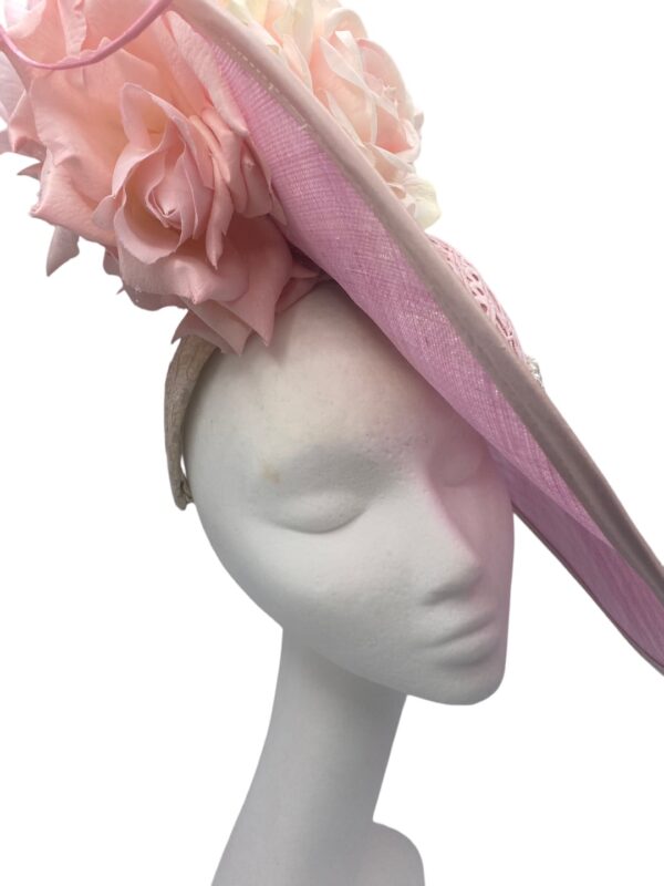Pink side saucer headpiece with pearl trim and flower detail. Headband to hold in place.