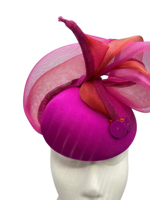 Stunning vibrant pink headpiece with subtle orange trim detail to the pink swirl.