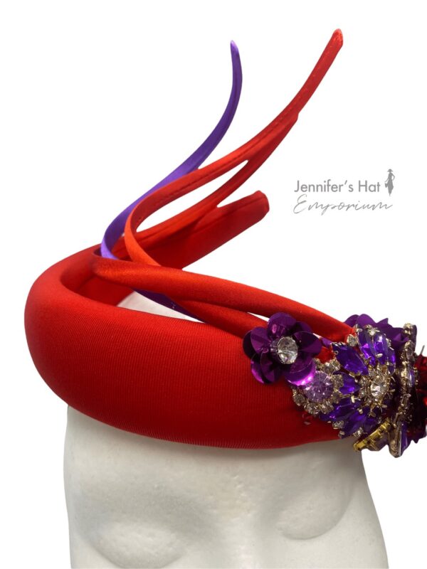 Stunning coral red coloured upright spiral crown with beautiful cadbury purple embellished design.