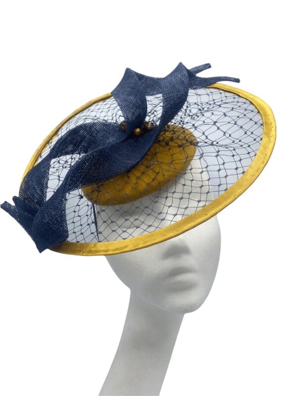 Mustard velvet headpiece with circular wire covered in mustard satin. Navy veiling over the entire headpiece with navy swirl detail.