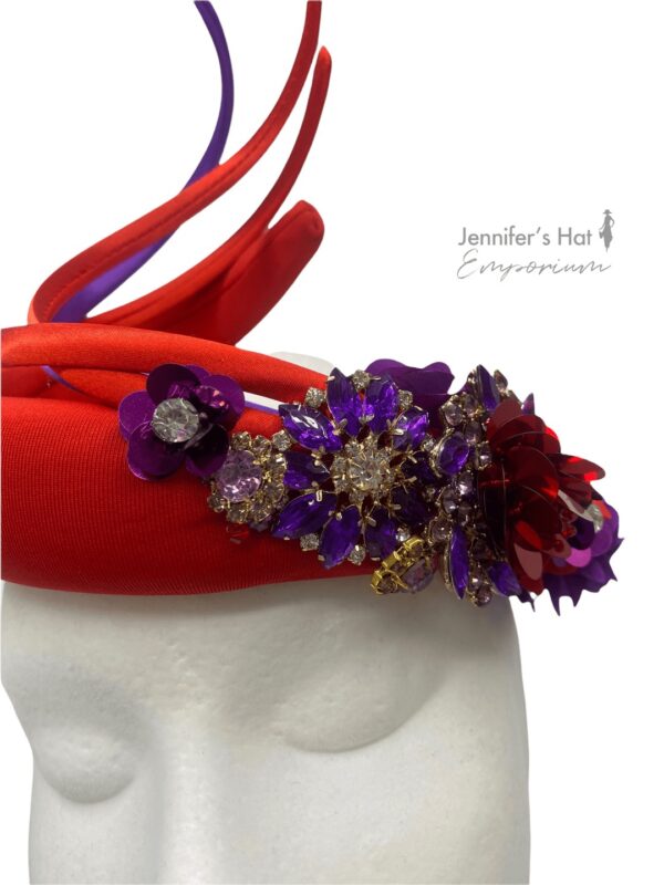 Stunning coral red coloured upright spiral crown with beautiful cadbury purple embellished design.