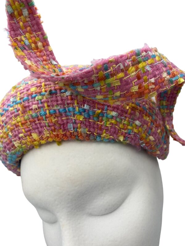 Stunning pink tweed hat with matching swirl detail. This headpiece has some colour through the tweed fabric.