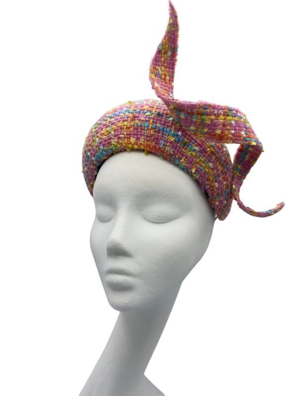 Stunning pink tweed hat with matching swirl detail. This headpiece has some colour through the tweed fabric.