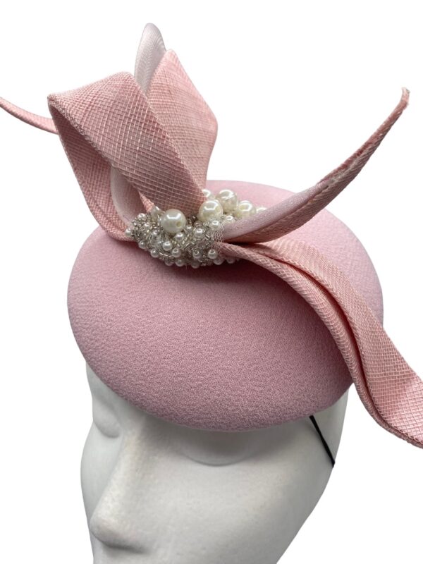 Baby pink headpiece wuth stunning swirl detail, finished with silver beading detail. Perfect hat for mother of the bride or mother of the groom headpiece.