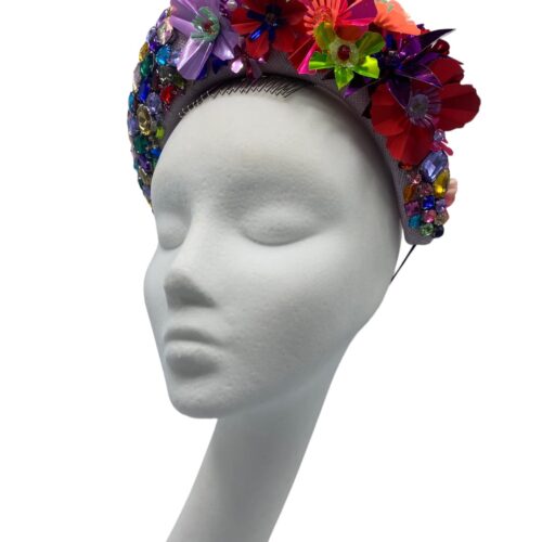 Stunning multicoloured foil headpiece on front with an array of multicoloured foam handmade flowers to the back.
