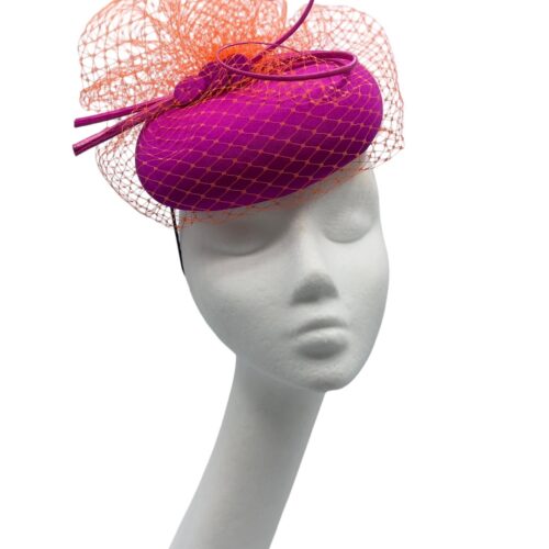 Gorgeous magenta pink headpiece with stunning orange veiling overlay with orange quill to finish.