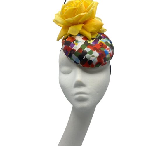 Multi-coloured headpiece with yellow flower.