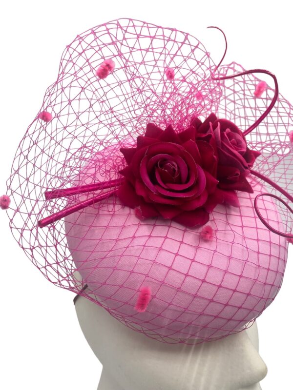 Stunning baby pink headpiece with fuchsia pink veiling and flower contrast detail.