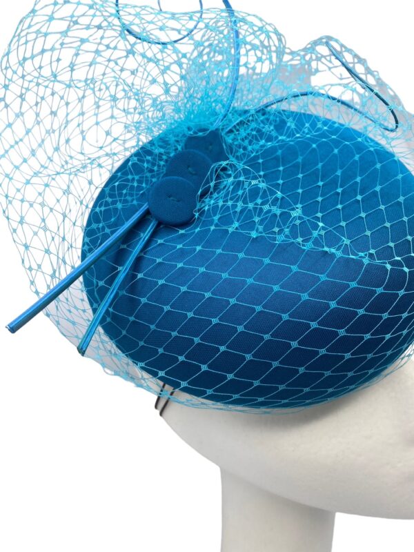 Teal rasied pillbox headpiece with stunning teal veiled and quill detail to finish.