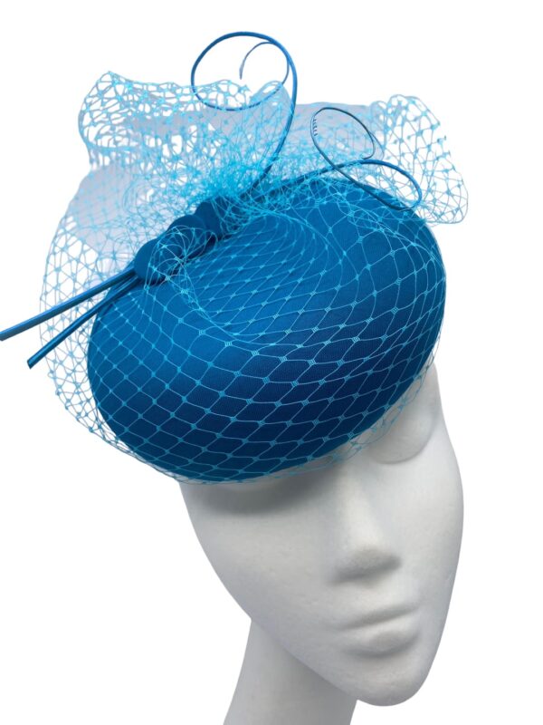 Teal rasied pillbox headpiece with stunning teal veiled and quill detail to finish.