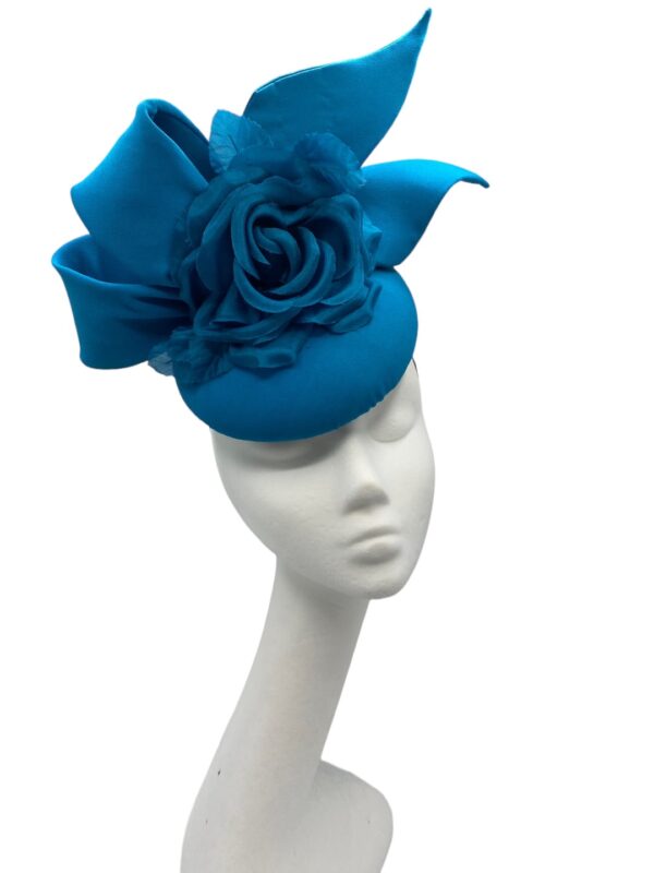 Stunning teal side bow headpiece with flower detail.