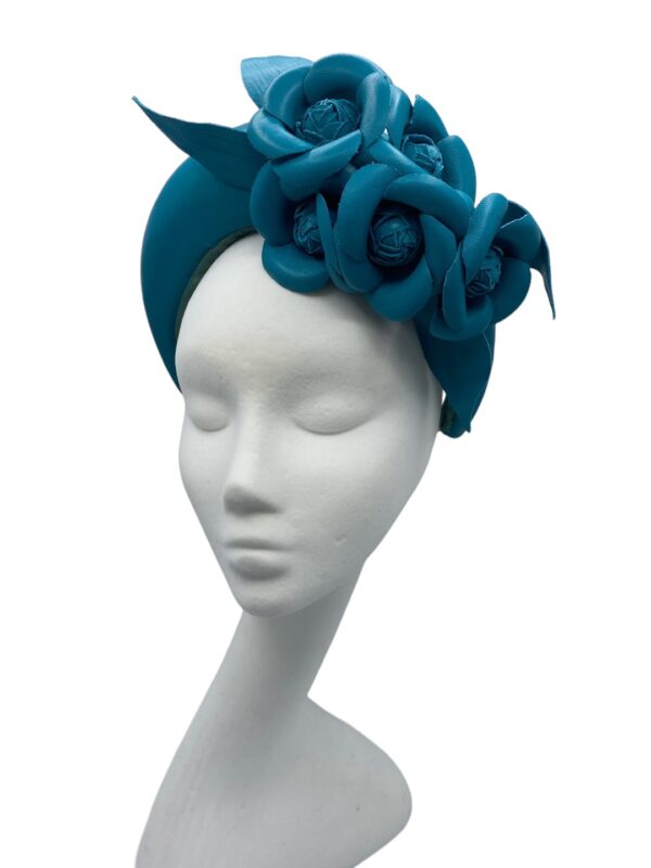 Teal leather crown with leather flower detail.