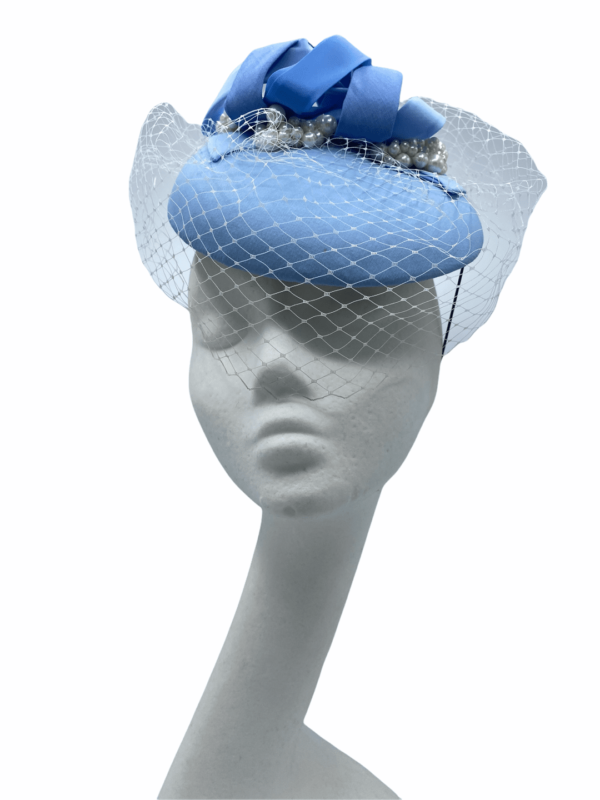 Stunning baby blue headpiece with white  face veiling overlay. This headpiece also has a number of different blue swirls on the top to tie in multiple blue tones.